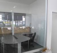 A glass-walled office with furniture and windows in commercial premises.