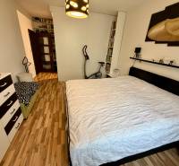 Bedroom with a double bed and a wooden decor floor in a 3-room apartment.