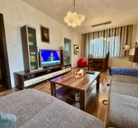 Living room in a three-room apartment with a wooden decor floor and a comfortable sofa.