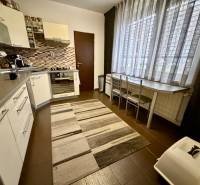 A kitchen in a 3-room apartment with a dark floor and a large window.