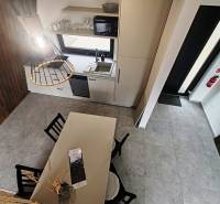 The interior of the cabin with a dining table, kitchen counter, and wooden floor decor.