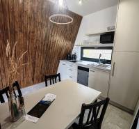 A kitchen in a cabin with a wood-patterned floor, wooden walls, and modern equipment.