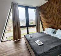 A room in a cabin with a view, a bed, and a wooden decor floor.
