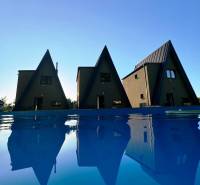 Cottages on Eva Street in Holčíkovce by the pool with a blue water surface.
