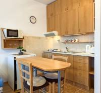 Studio apartment with a kitchenette, table and chairs, wooden decor flooring.