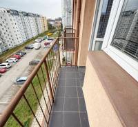 The balcony of a studio apartment on Východná Street in Trenčín with a view of the parking lot and buildings.