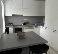A kitchen in a 2-room apartment with simple equipment and a floor with a wooden decor.