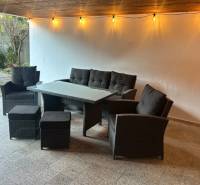 Outdoor seating with rattan furniture and lights on the terrace.