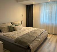 A bedroom in a two-room apartment with a bed and a floor with a wooden decor.