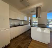 A kitchen in a 4-room apartment with light cabinets and a wood-patterned floor.