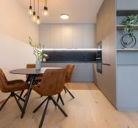 Dining area with wood-patterned flooring and stylish lighting in a 2-room apartment.