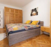 Bedroom in a 2-room apartment with a bed, wooden wardrobe, and floor with a wooden decor.