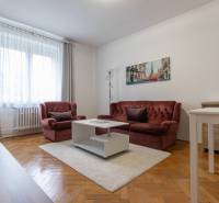 Living room with a red sofa, white table, and wooden decor flooring.