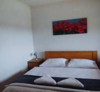 A bedroom with a double bed and wooden nightstands in a 2-room apartment.