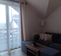 Living room in a two-room apartment with a sofa, coffee table, and a view of the balcony.