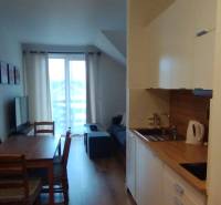 Kitchen corner and dining table with chairs, 2-room apartment, floor with wooden decor.