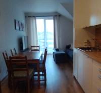 Kitchen corner with a dining table and floor with wood decor in a 2-room apartment.