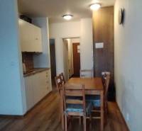 Interior of a 2-room apartment with a wooden decor floor and a dining table.