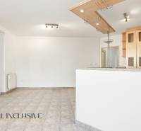 A kitchen in a 2-room apartment with a tiled floor and wooden cabinets.