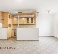 A kitchen with a corner unit in a 2-room apartment, tiled floor, white walls.