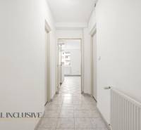 A corridor in a 2-room apartment with white walls and tiles.