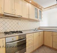 A kitchen in a 2-room apartment with a gas stove and light kitchen cabinets.
