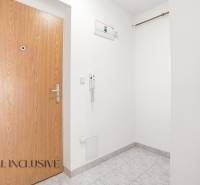 Entrance hall with white walls and tiles in a 2-room apartment.