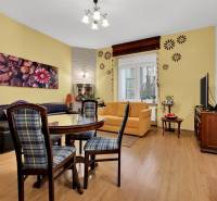 Living room with comfortable seating, dining table, and wooden decor flooring in a 3-room apartment.