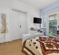 Bedroom in a 3-room apartment with a bed, shelves, and a floor with a wood decor.