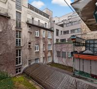 A view of the courtyard of apartment buildings with old plaster and a balcony.