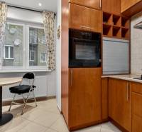 A kitchen in a 3-room apartment with a dining area and wooden cabinet decor.