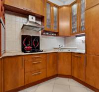 A kitchen in a 3-room apartment with wooden furniture and built-in appliances.