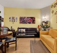 Living room in a 3-room apartment with wooden decor flooring and comfortable seating.