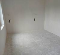 Empty room with a concrete floor in a family house.
