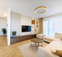 Living room in a two-room apartment with a wooden decor floor and a spacious sofa.