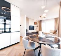 2-bedroom apartment with a dining table, sofa, and wooden decor flooring.