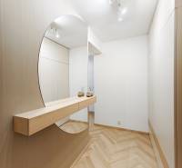 Entrance hall with wood-patterned flooring and a large mirror in a 2-room apartment.