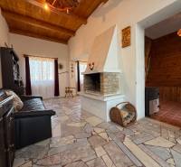 A cottage with a fireplace, a comfortable sofa, and a wooden-patterned floor.