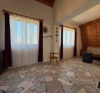 Interior of a cabin with a stone floor and stylized furniture.