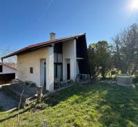 A cottage in Zlaté Moravce surrounded by a garden and lawn under a clear sky.