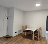 Dining area with a table and chairs, wooden decor flooring in a 3-room apartment.
