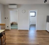 A kitchen in a 3-room apartment with a wooden decor floor and a dining table.