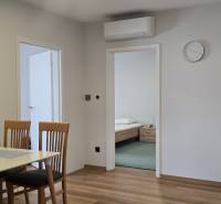 Dining table with chairs and a wooden-patterned floor in a 3-room apartment.