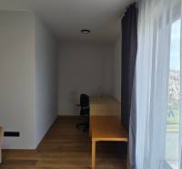 Room in a 3-room apartment with a wooden decor floor, table, and sofa.