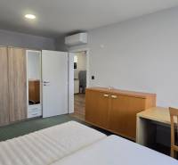 A bedroom in a 3-room apartment with a double bed, a wardrobe, and a table.