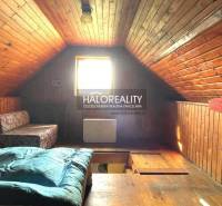 An attic room with wooden paneling, creating a cozy atmosphere, in a cabin.
