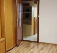 Wooden furniture in a 3-room apartment with parquet flooring and open shelves.