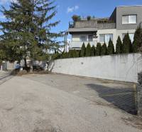 Garages on Vavrínova Street in Bratislava - Ružinov with surrounding greenery and houses.