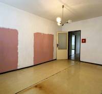 A room with unique walls and a wooden decor floor in a 3-room apartment.