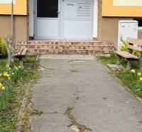 Entrance to the building on Škultétyho Street in Trebišov with benches and flower beds.